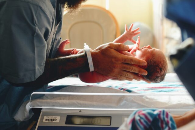 a baby being held in the ICU
