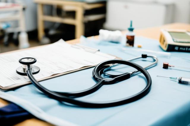 A triage desk in an emergency room with a stethoscope left unused alongside disorganized medical tools, emphasizing inefficiencies and the impact of triage errors on patient care.